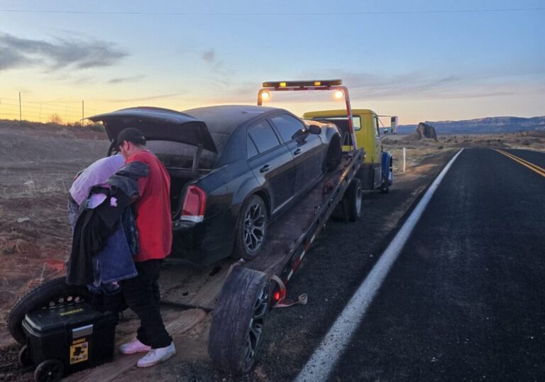 Baby Rocks Towing team loading a disabled car onto a flatbed tow truck during a 24-hour emergency roadside recovery call.