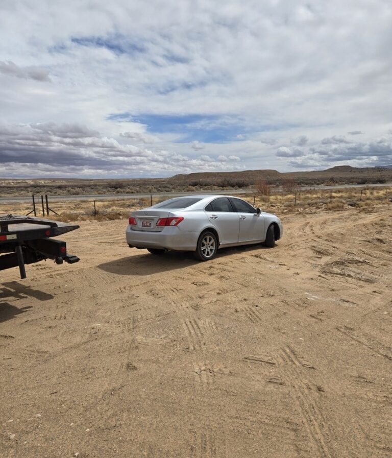 Baby Rocks Towing arriving to provide off-road vehicle recovery and roadside assistance for a disabled car stuck on a dirt shoulder.